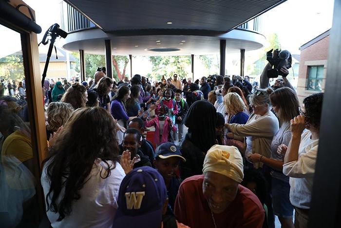 a crowd of people includes children and adults and are moving toward the camera