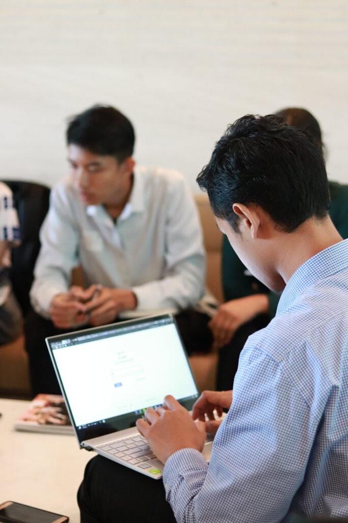 Students around table, one on laptop